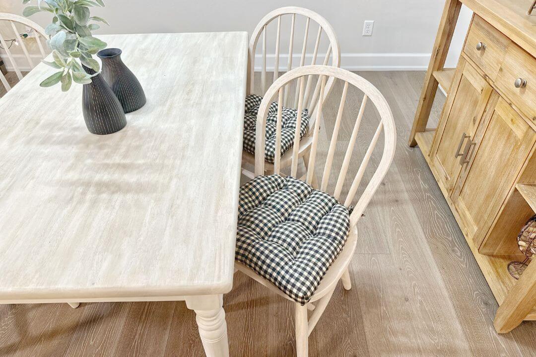 After Photo - Rustic whitewashed dining chairs with farmhouse chair pads