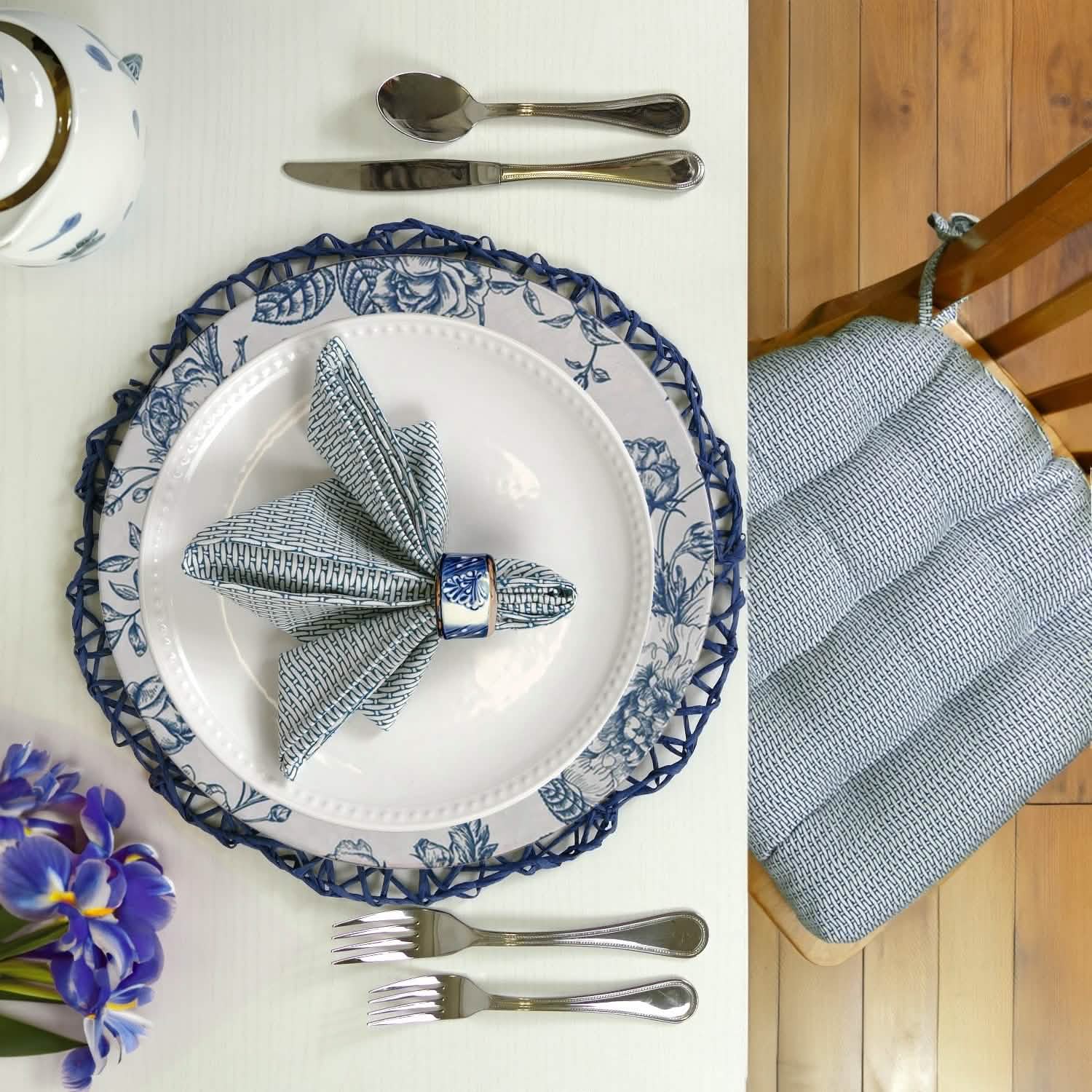Close up of table set with basketweave blue chair pad and napkin