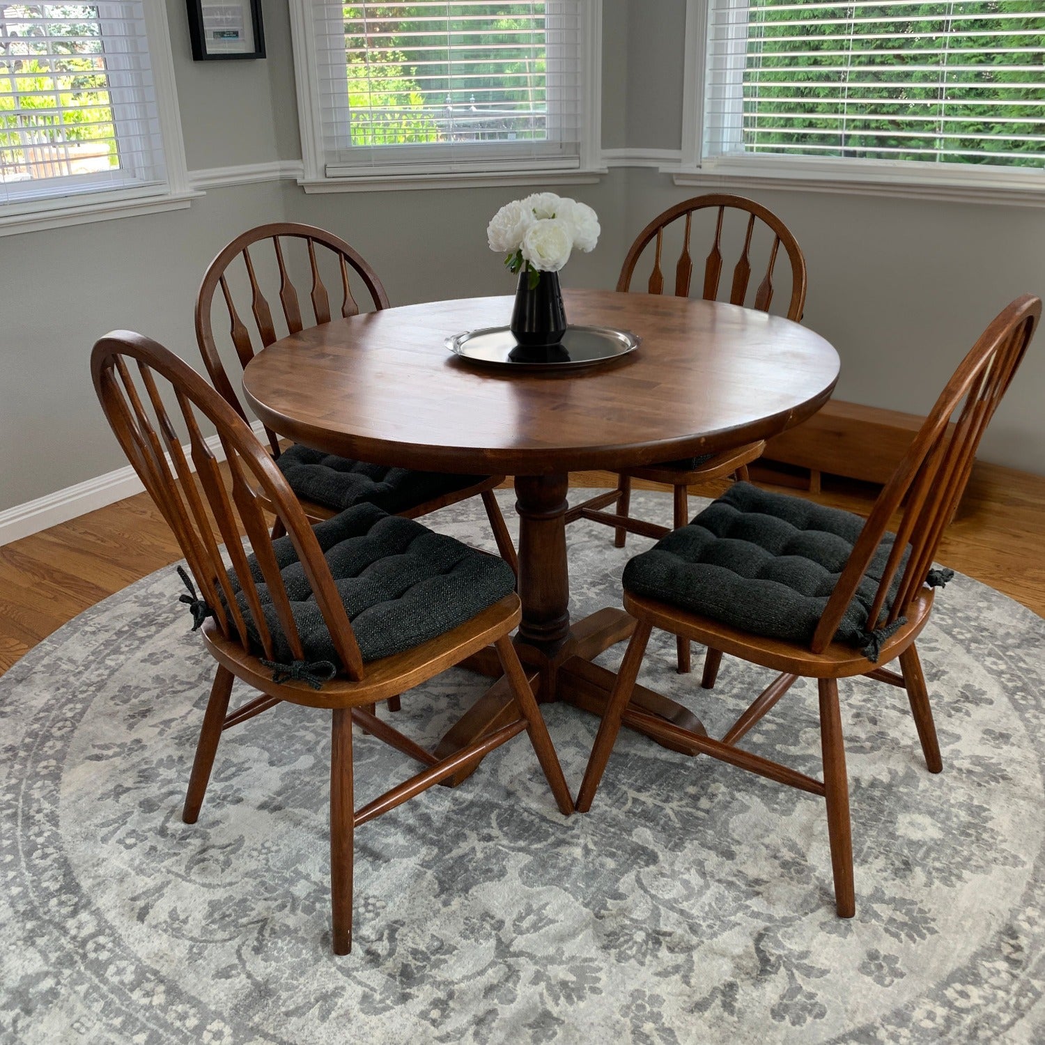 dark gray dining chair pads on windsor chairs in traditional dining room with grey rug and wood dining room chairs