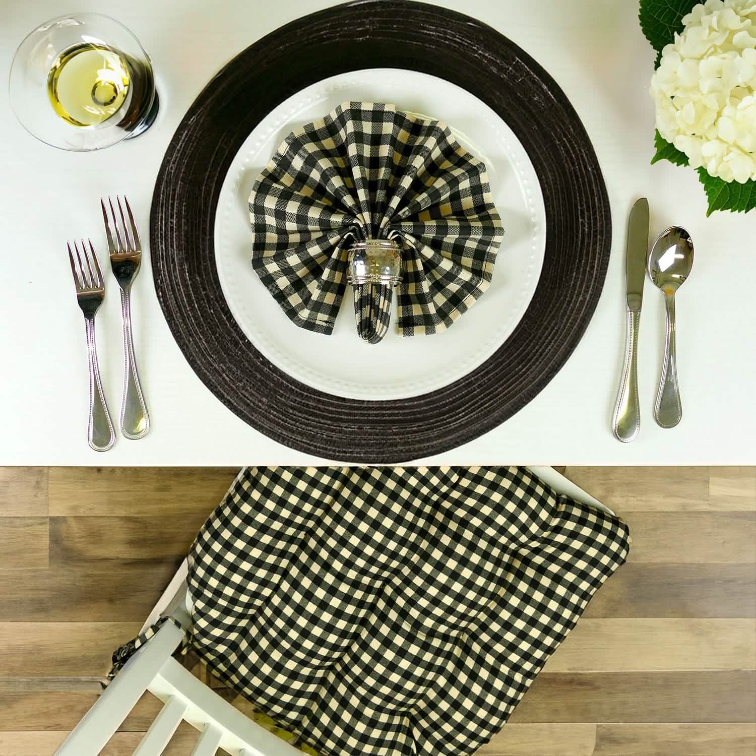 Black and white checkered napkin on a plate with matching dining chair cushions