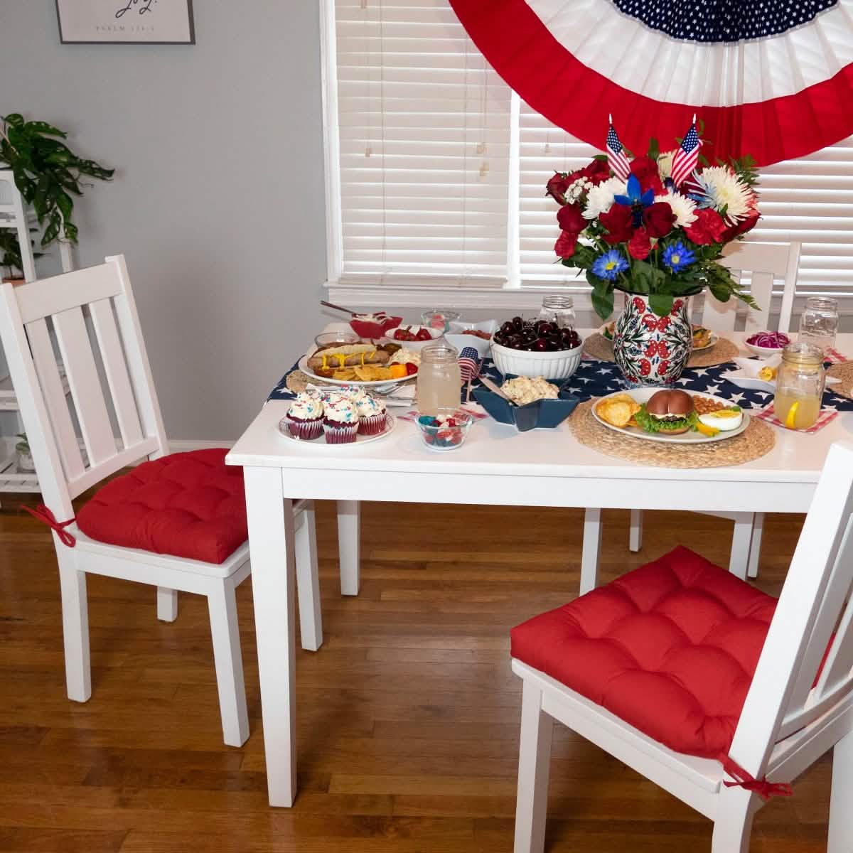red cotton dining room chair cushions on white dining chairs at farmhouse table set for independence day celebration