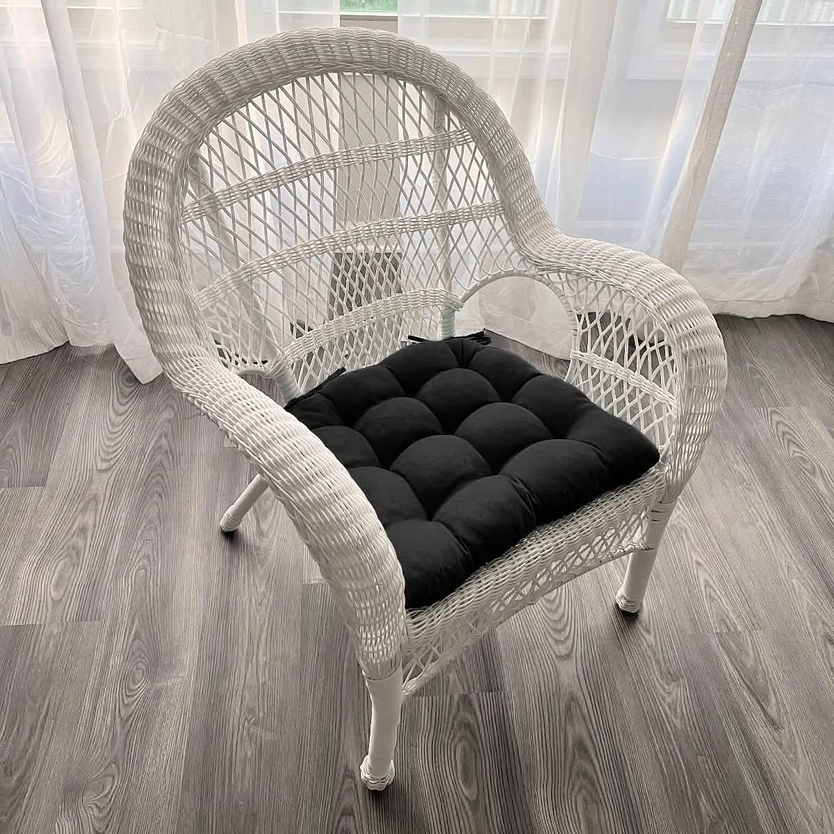 microsuede black cushion on white wicker chair