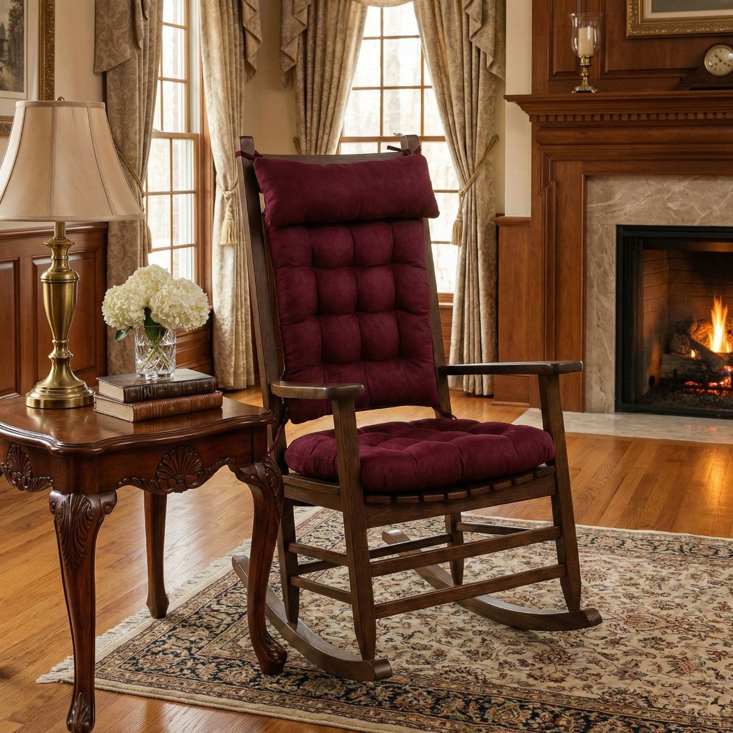 Wooden rocking chair with red cushions in a cozy living room with a fireplace.