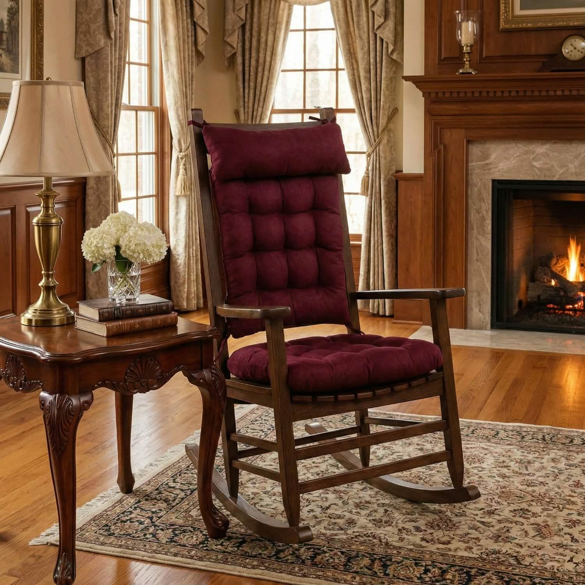 Wooden rocking chair with red cushions in a cozy living room with a fireplace.
