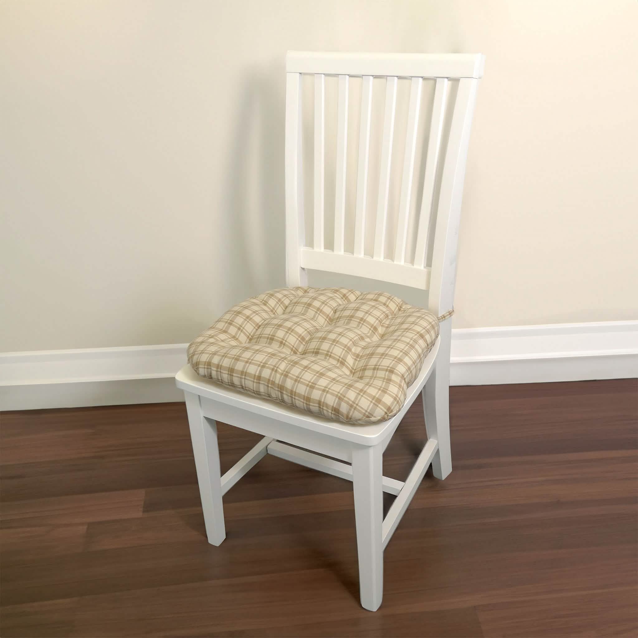 Beige tan plaid dining chair cushion placed on white wooden dining chair in bright dining room