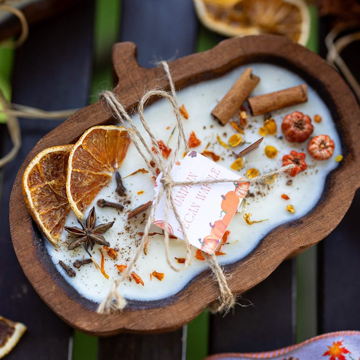 natural soy candle in a wooden pumpkin shaped dough bowl with cirus and cinnamon