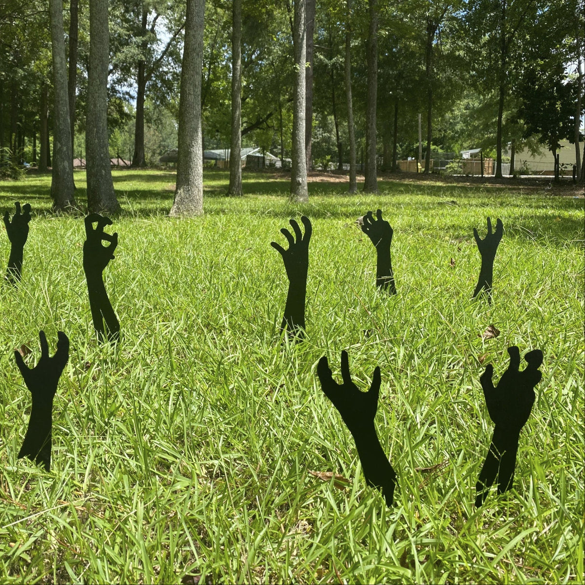 black metal zombie hands reaching from the grass for halloween yard decorations