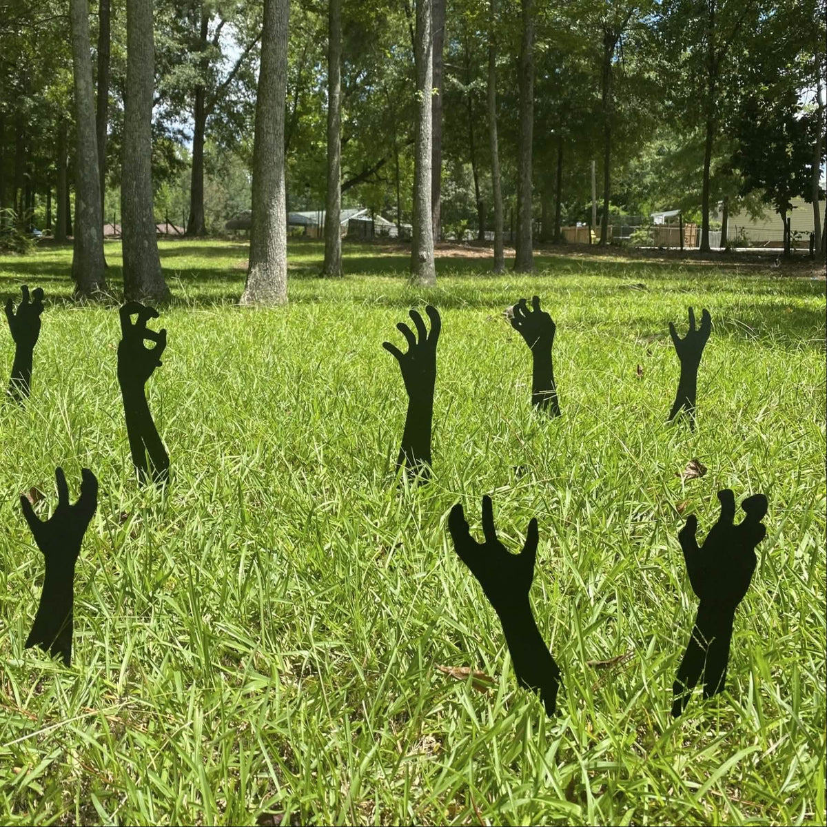 black metal zombie hands reaching from the grass for halloween yard decorations