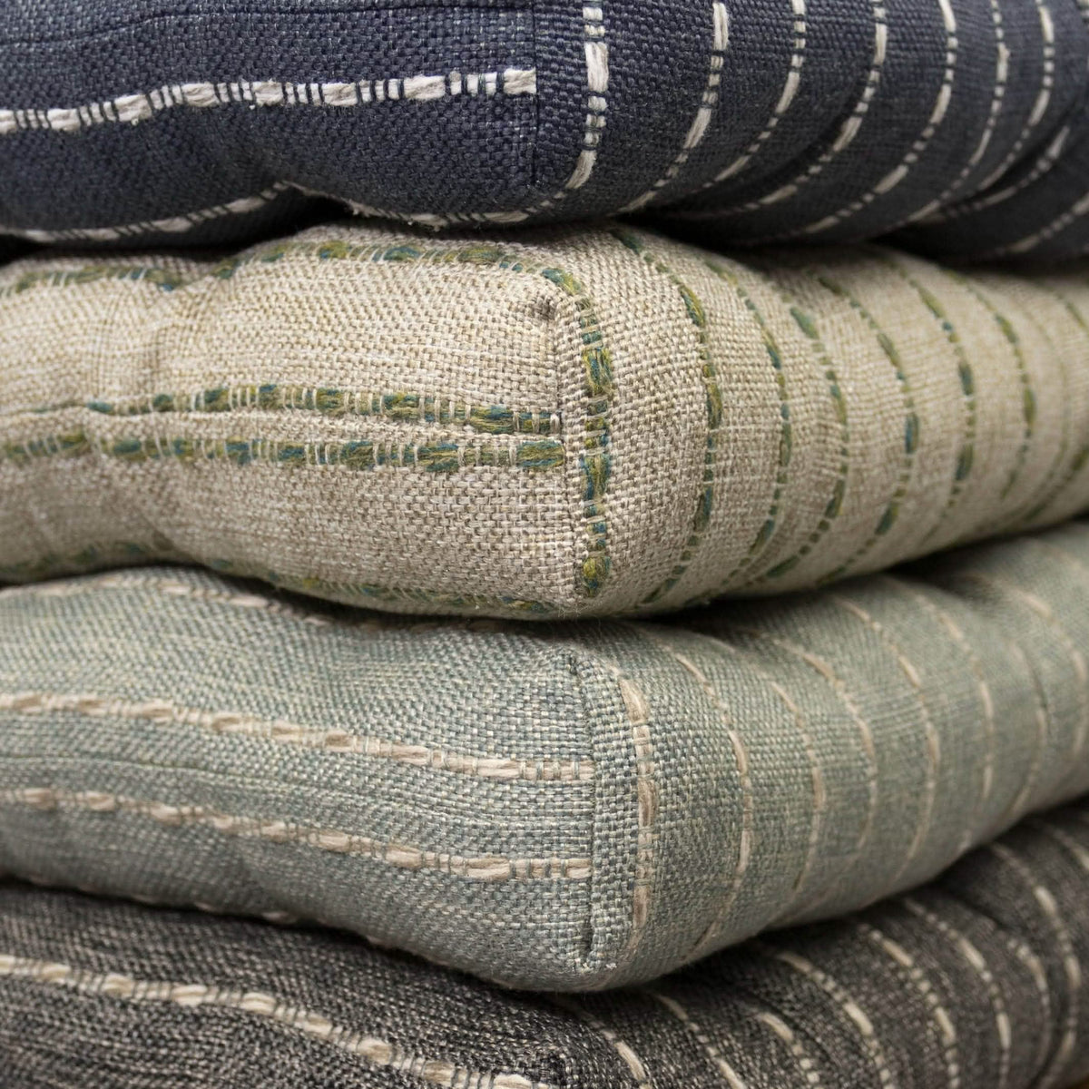 Stack of avante chair pads in navy blue green spa and charcoal black color options