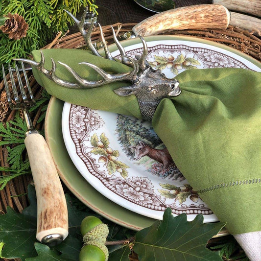 elk napkin ring with cloth napkin at rustic lodge tablescape with deer antler and stag horn accessories