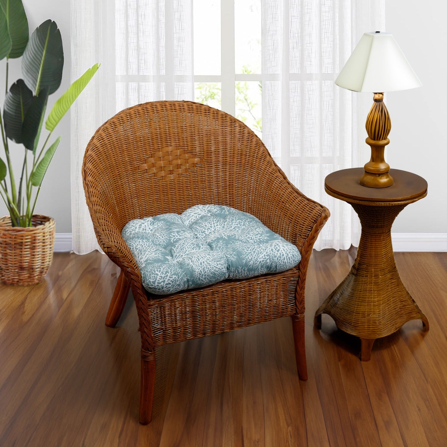 wicker chair cushion with fan coral pattern in aqua on a rattan chair in a plantation style living room