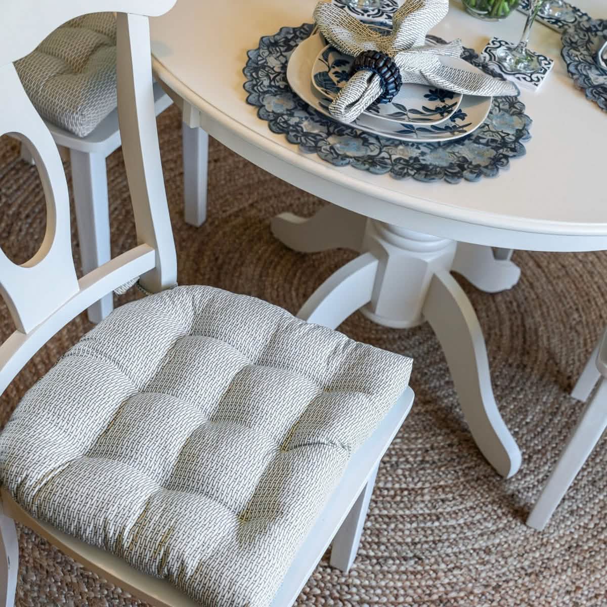 Basketweave slate gray dining chair pad on wooden chair with matching napkin.