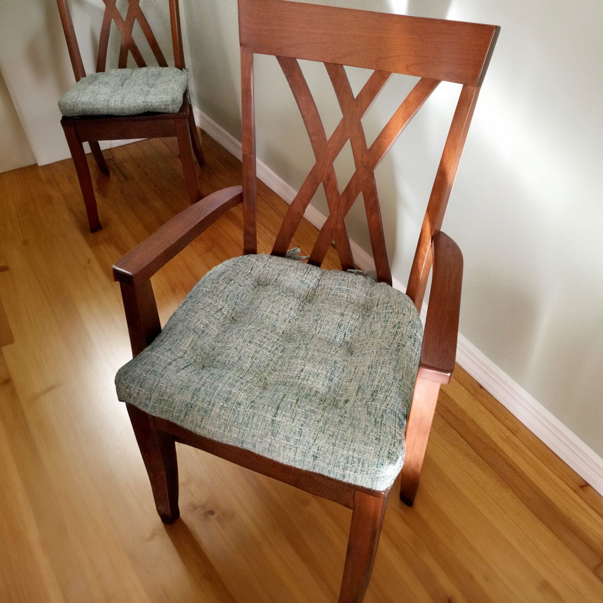 Close up of boucle dining chair cushion on wooden chair.