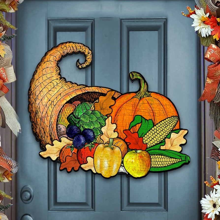 Decorative door mat with cornucopia, pumpkins, and fall elements on a blue door.