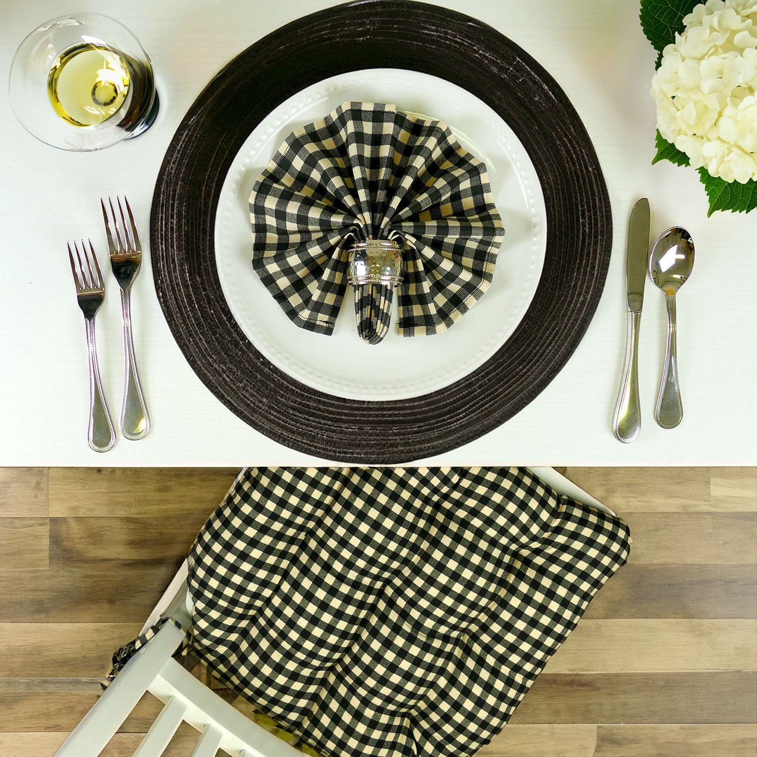 Black and white checkered napkin on a plate with matching dining chair cushions