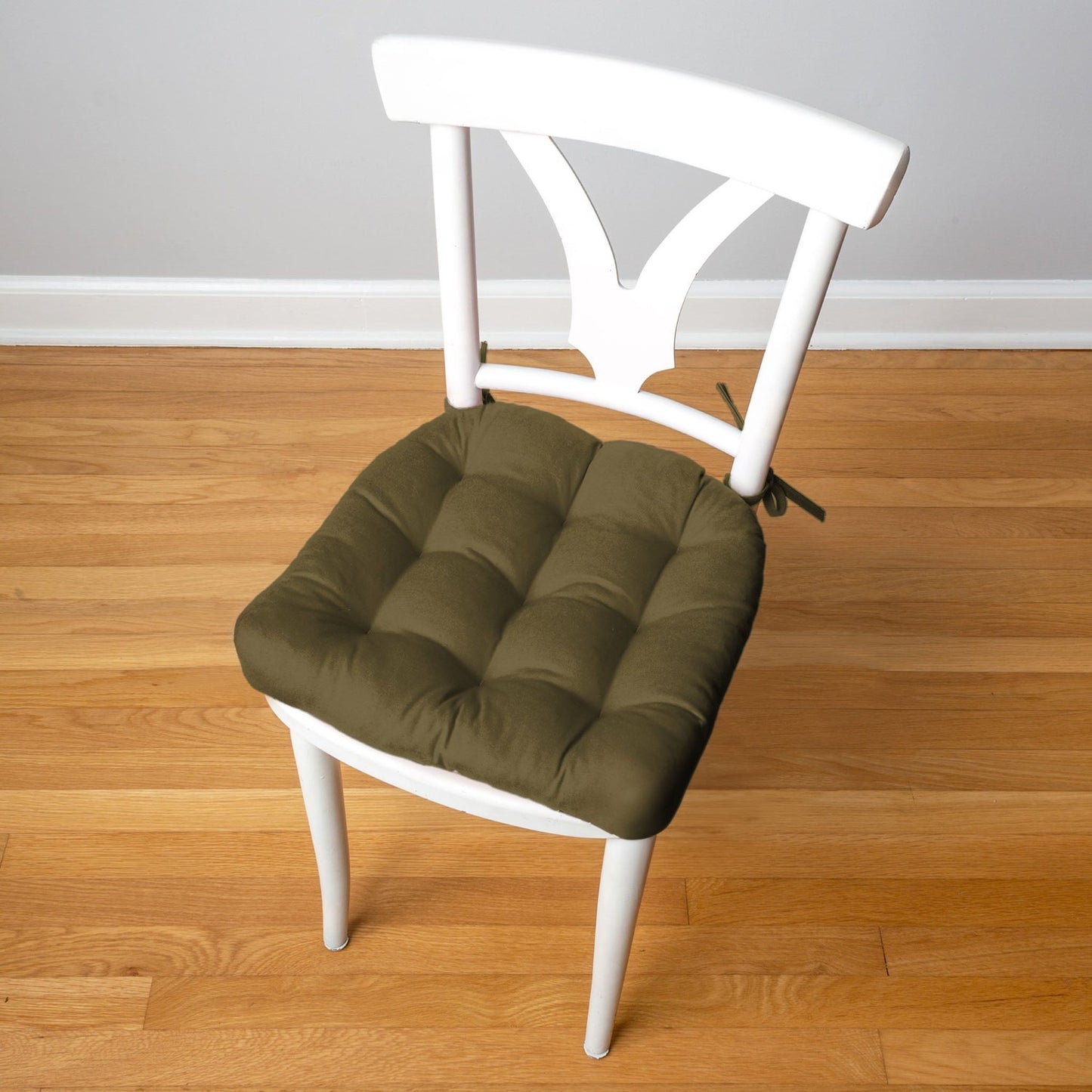 olive green chair pad on a white mid-century dining room chair