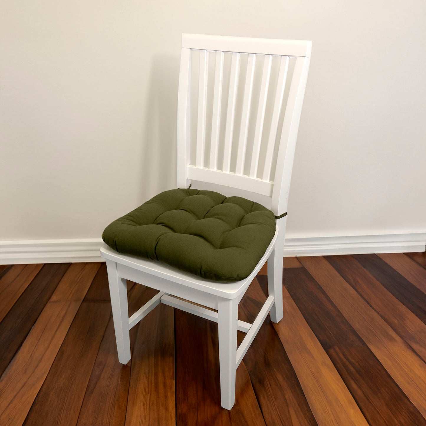 olive green chair pad with ties on white dining chair in traditional dining room