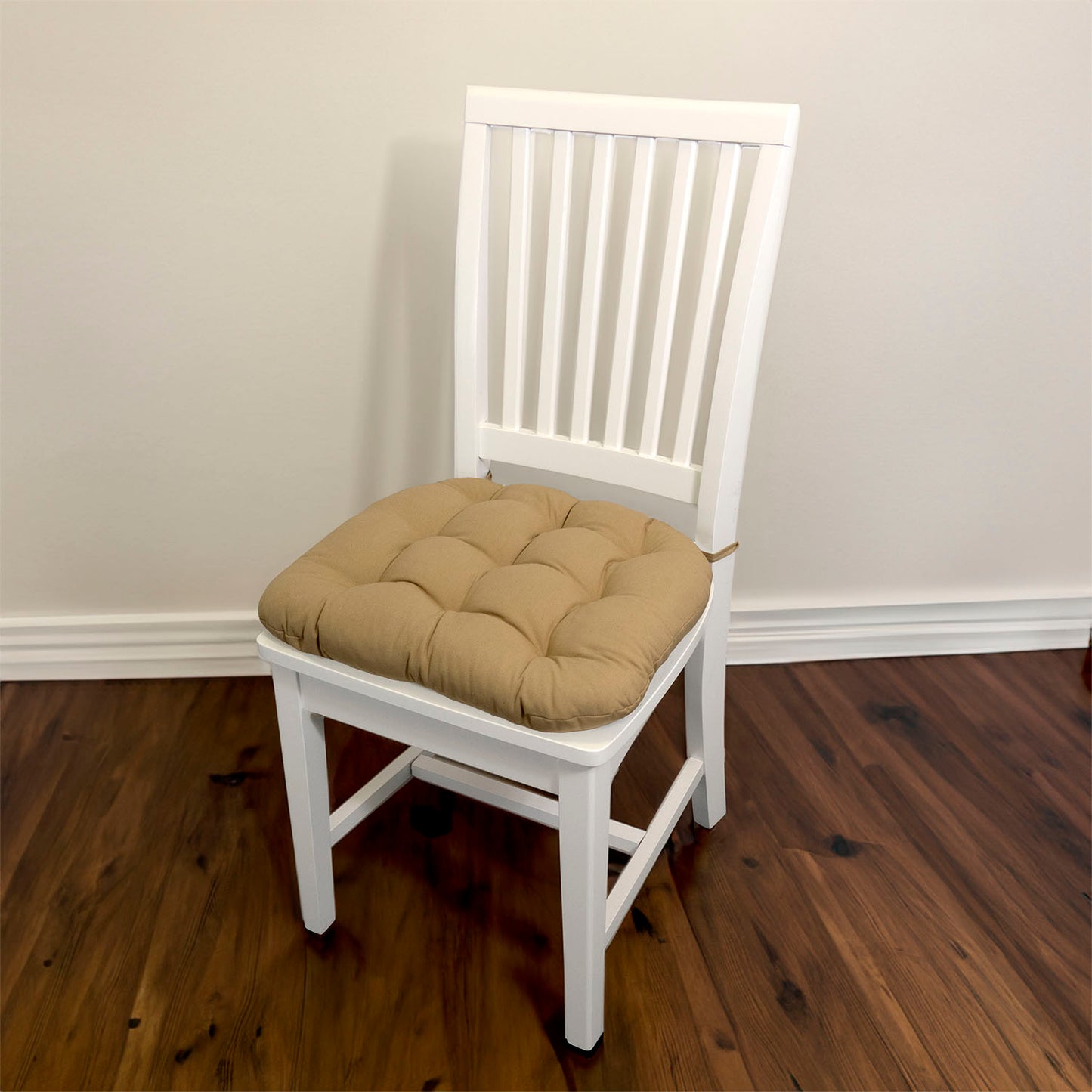 tan dining chair pads with ties on a white dining chair in a traditional dining room