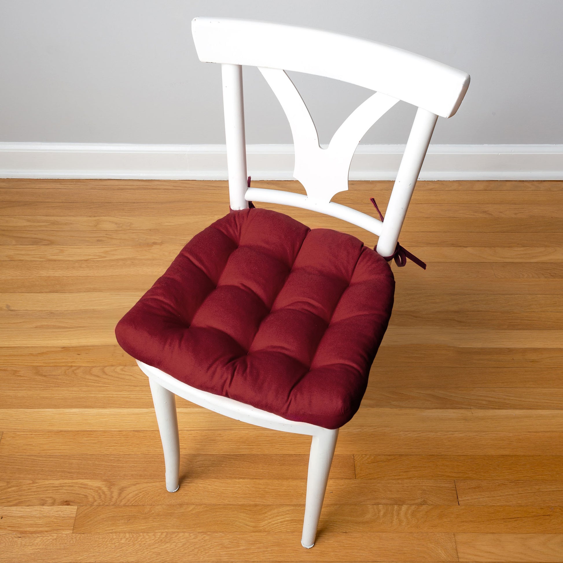 burgundy red chair pad on a white mid-century dining room chair
