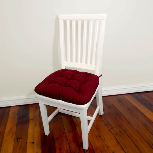 wine red dining chair pad with ties on a white dining chair in a traditional dining room