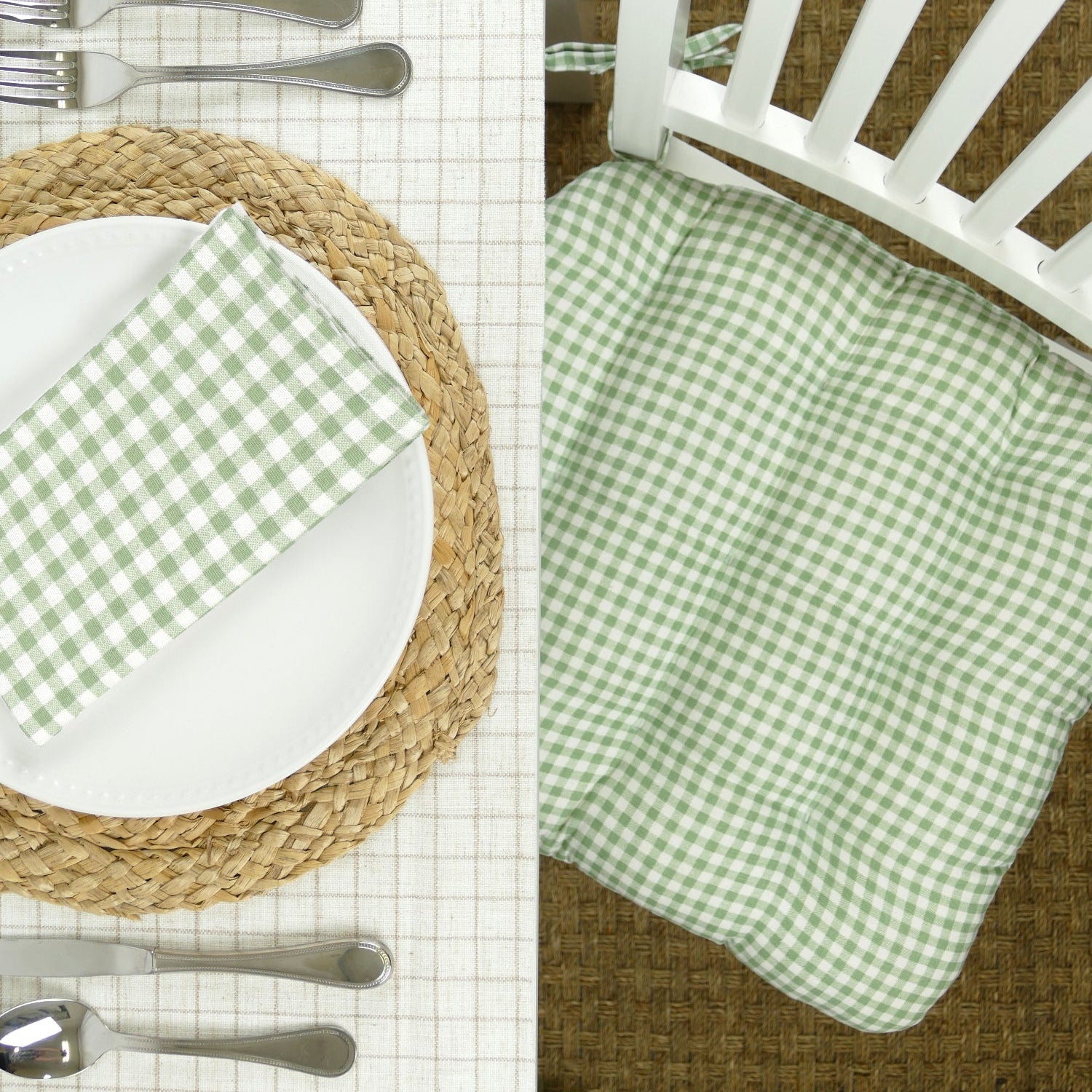 Green checkered placemat on a woven mat with white plate and silverware.