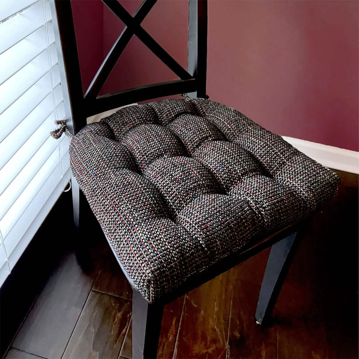Nala black dining chair pad with reversible design showing detailed tufted texture and secure tie attachments