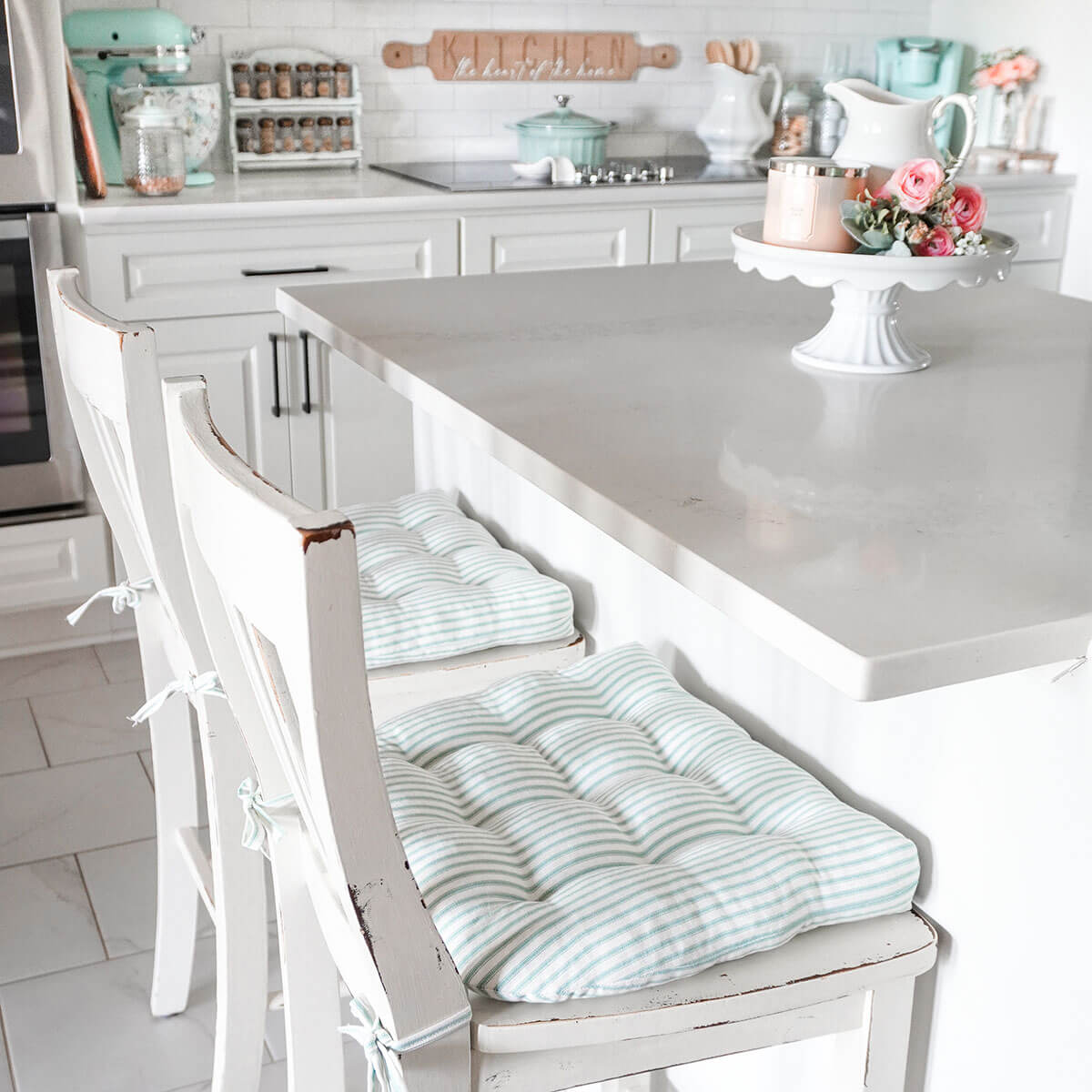 aqua ticking stripe dining chair cushions on bar height chairs at kitchen island in farmhouse style kitchen by kate schwanke