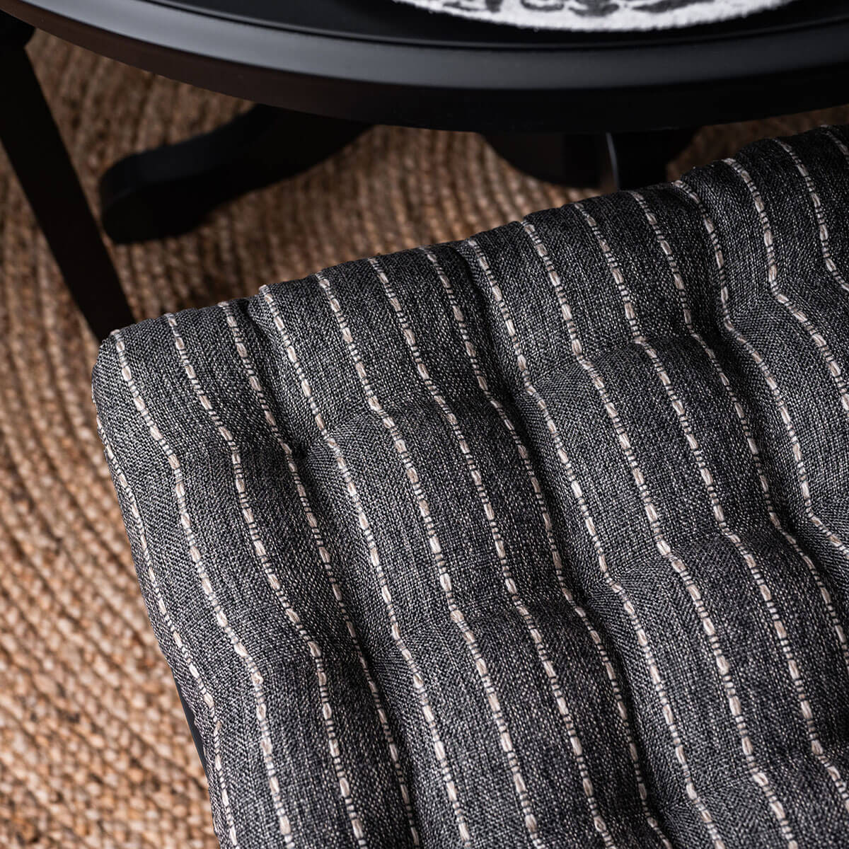 detail view of black striped dining chair cushion with upholstery fabric cover