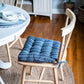 closeup of navy blue striped chair pad with ties on wooden dining room chair