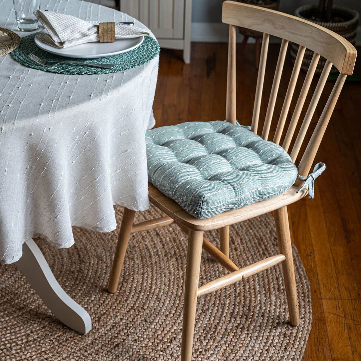 white and aqua striped dining room chair cushion on natural windsor chair in coastal farmhouse dining room