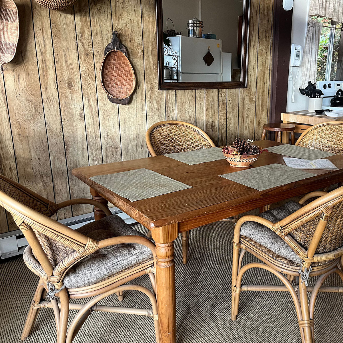 neutral colored dining chair pads on rattan chairs in rustic dining room with sisal rug and woven baskets