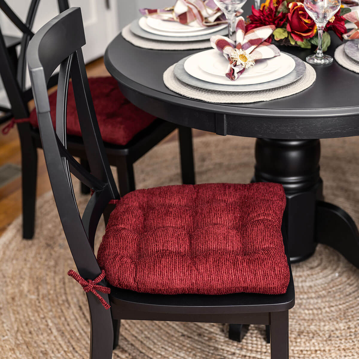 wine red corduroy dining chair pads on black crossback dining chairs in formal dining room