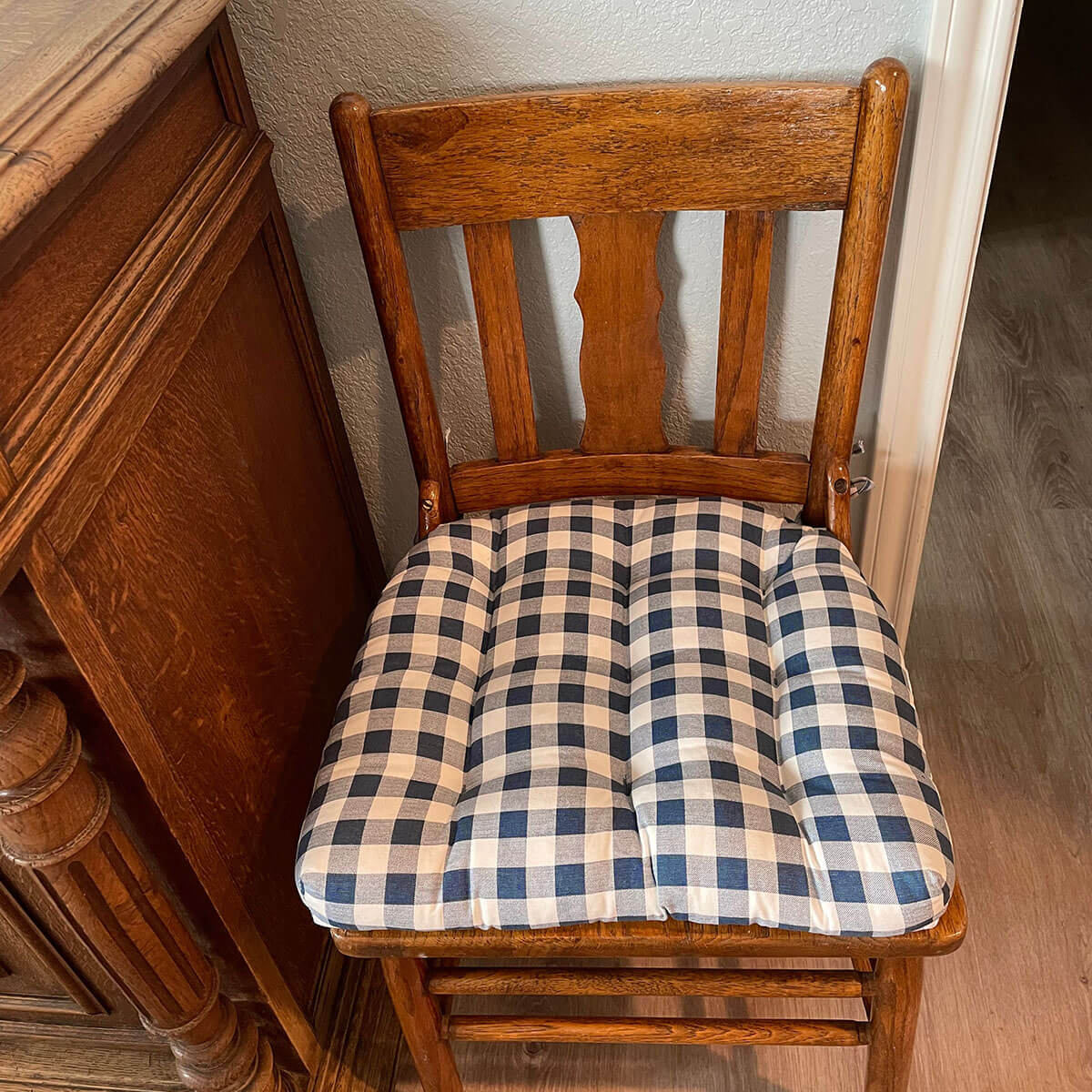 navy blue buffalo check chair pads on a wooden dining chair in a traditional dining room