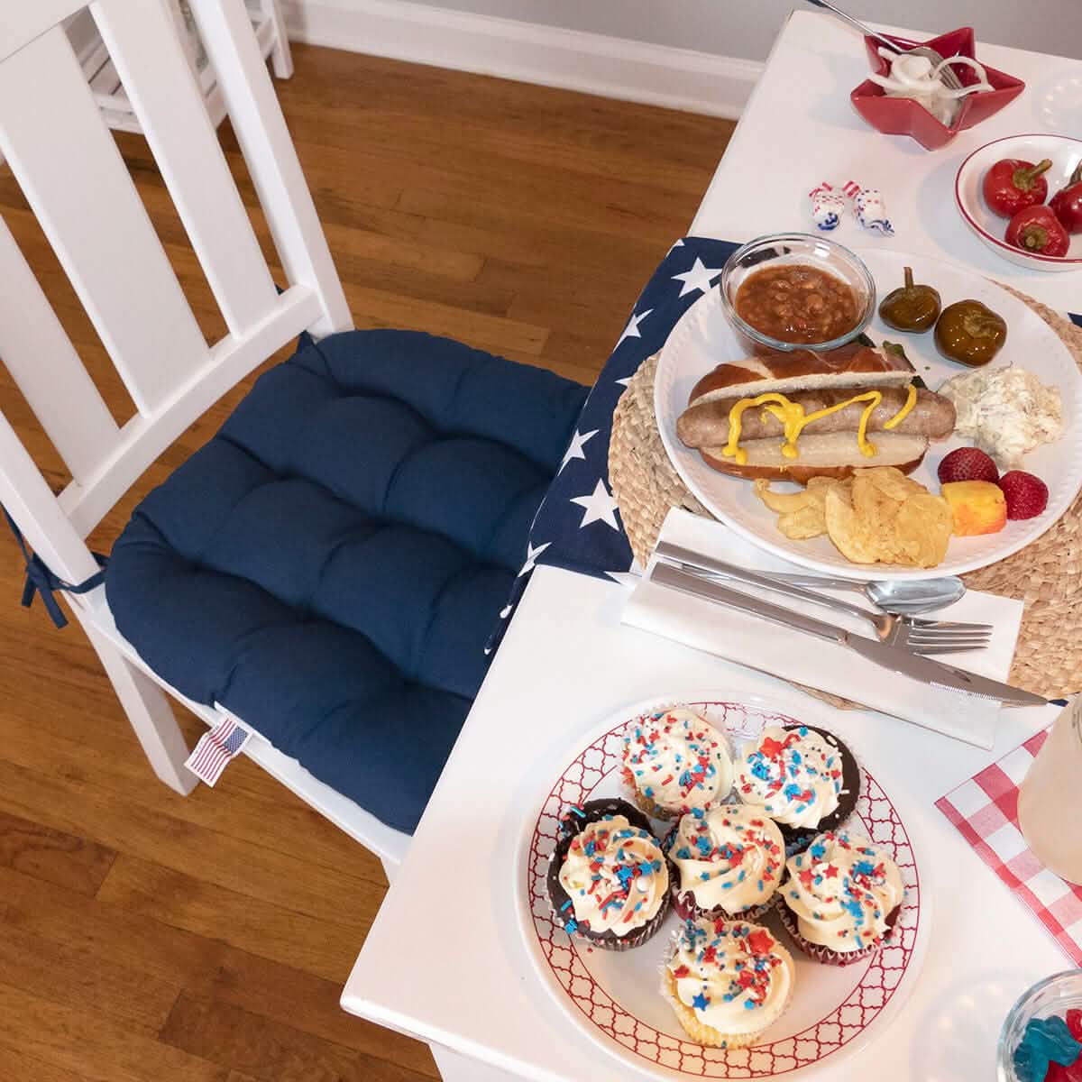 dark blue chair cushions on white dining room chairs at white contemporary dining table set for 4th of july family get-together