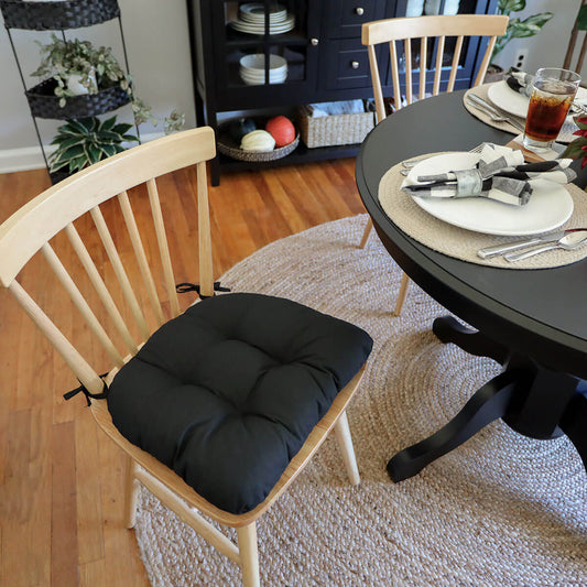 black dining chair pad on natural wooden dining chair with round black dining table