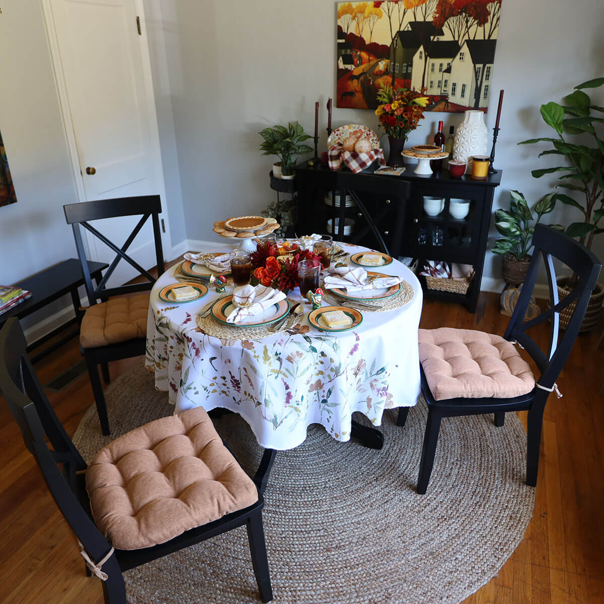 thanksgiving tablescape with copper dining chair cushions on black chairs in dining room decorated in fall colors