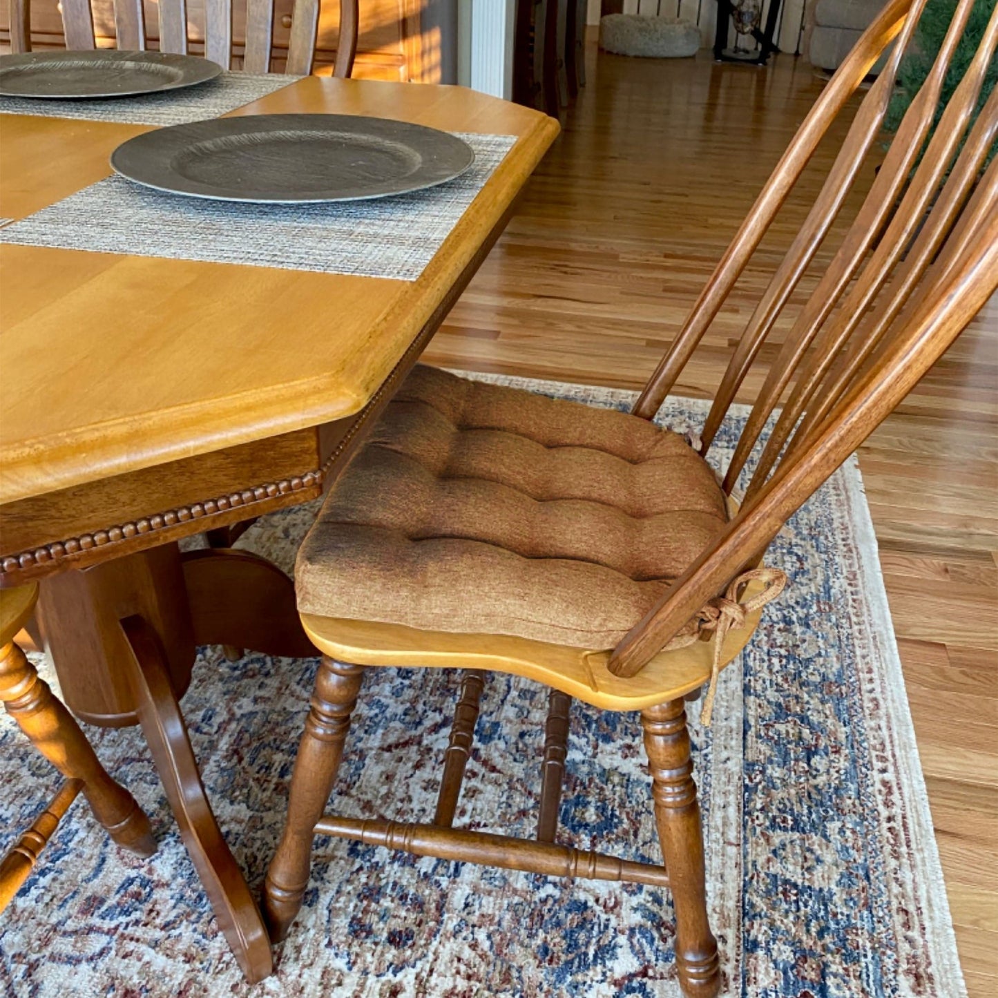 copper colored dining room chair cushions on wooden windsor chairs in formal dining room