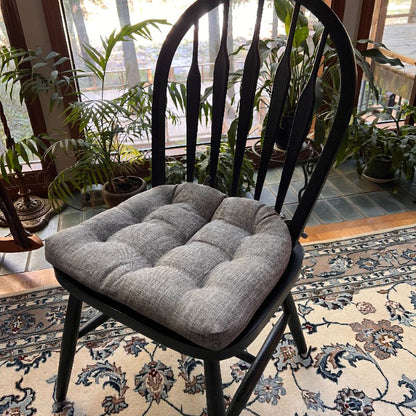 grey linen dining chair cushion on a black windsor chair in traditional dining room