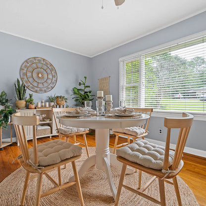 neutral colored dining chair cushions on natural colored wooden dining chairs in boho dining room