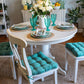 teal dining chair pads of vegan suede on white dining room chairs in farmhouse kitchen with teal pioneer woman tea goblets and plates