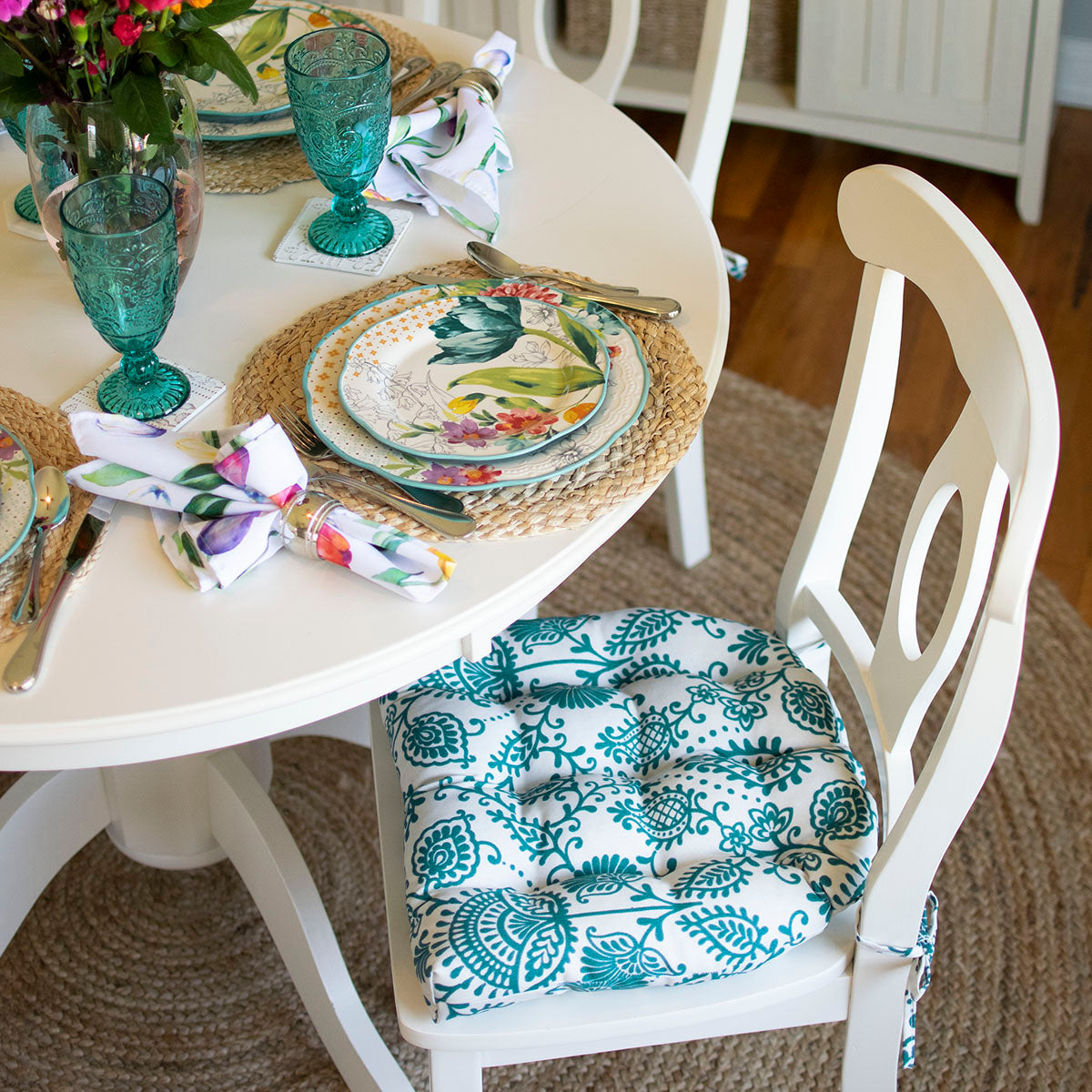 Teal dining chair cushions in farmhouse dining room with pioneer woman plates and goblets